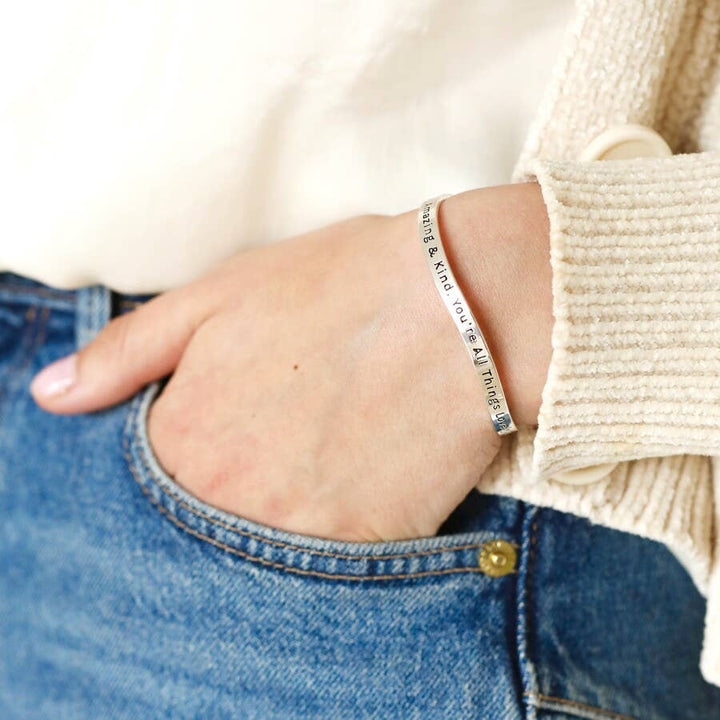 Adjustable silver bangle with a beautiful message. You're beautiful amazing, and kind you're all lovely things combined" inscribed on the bangle.