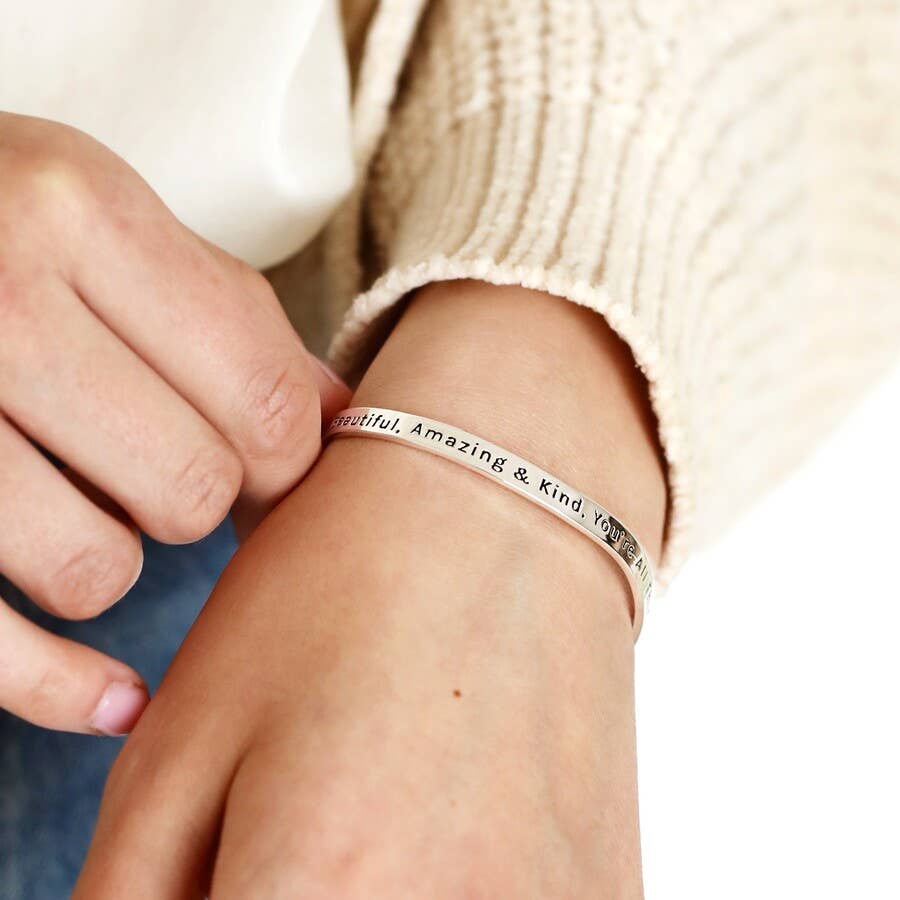 Adjustable silver bangle with a beautiful message. You're beautiful amazing, and kind you're all lovely things combined" inscribed on the bangle.