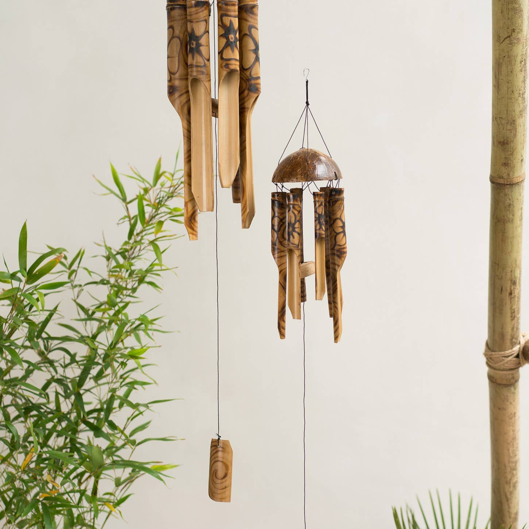 Bamboo wind chime with green plants on a light background