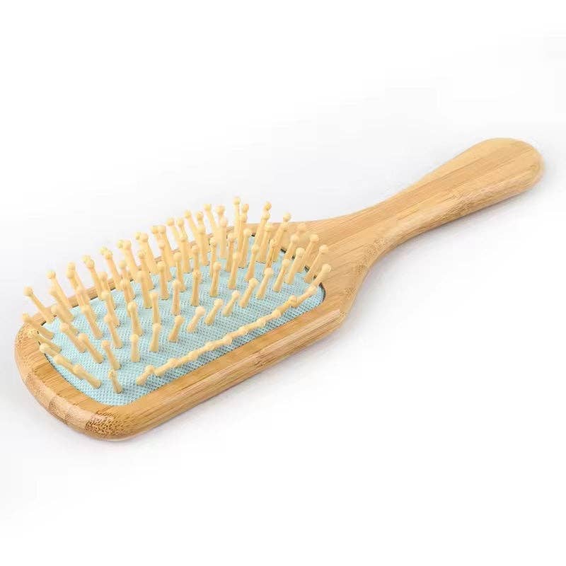 Wooden hairbrush with bristles on a white background