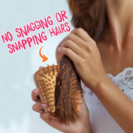 Person using a wooden hairbrush with text 'No Snagging or Snapping Hairs' on a light background