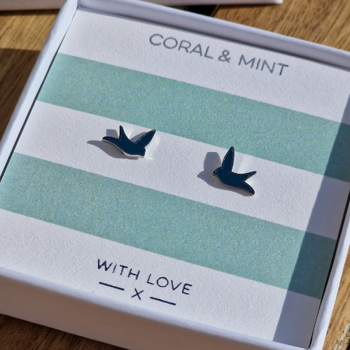 Bird-shaped earrings on a striped card with 'Coral & Mint' and 'With Love' text.
Silver plated stainless steel with blue enable