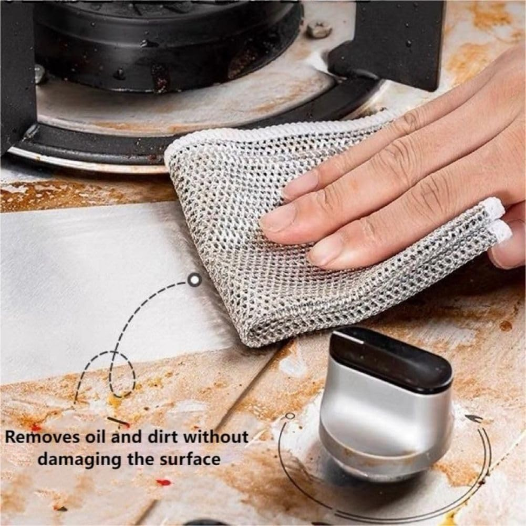 Person cleaning a stove with a double sided steel dishcloth and text indicating it removes oil and dirt without damaging the surface.