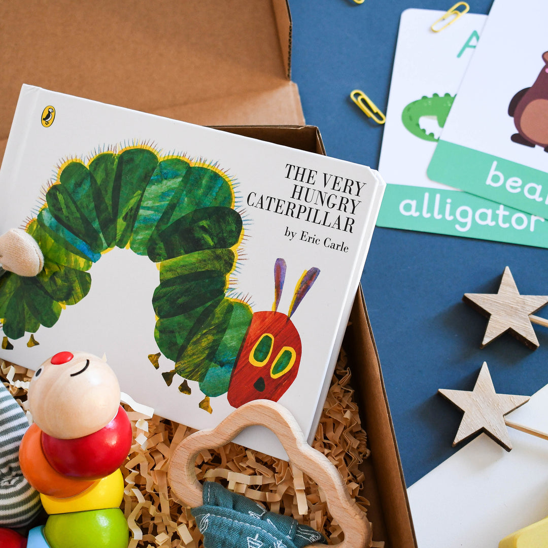 Eco Friendly New Baby gift box - Little caterpillar. Includes the hungry caterpillar board book, wooden rainbow classic world toy, striped comforter plush and wooden teether.