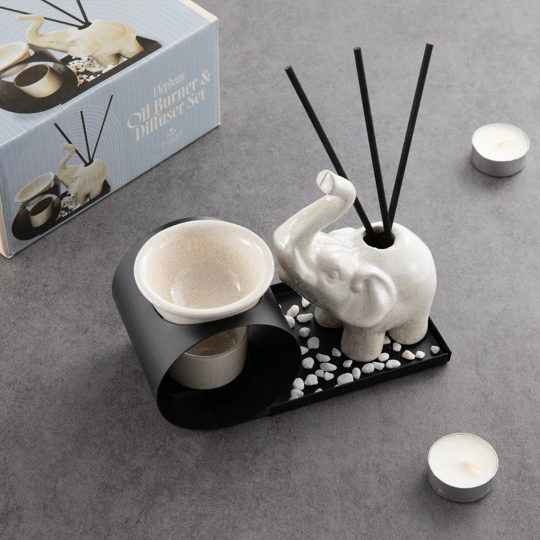 Decorative diffuser set with elephant design on a gray surface