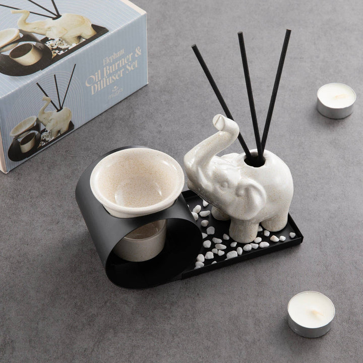 Decorative diffuser set with elephant design on a gray surface