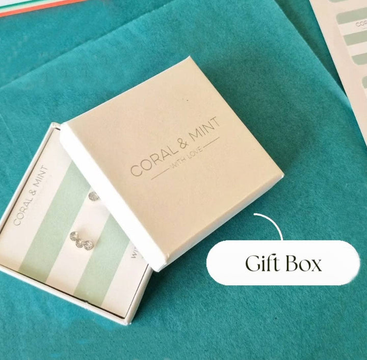 Gift box with 'Coral & Mint' branding on a teal background