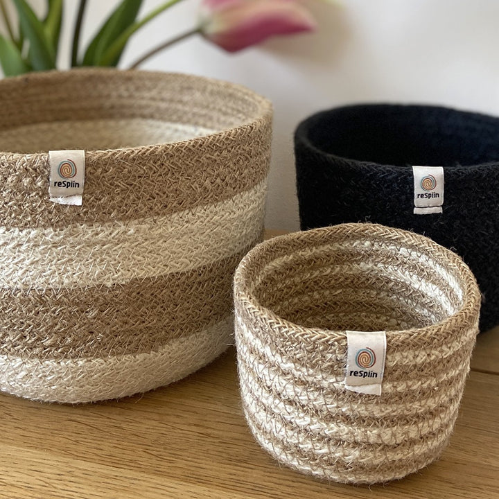 Natural Jute Basket Set – Pebble Design Large basket cream and brown with horizontal lines, medium basket plain black, small basket white and brown with horizontal lines 