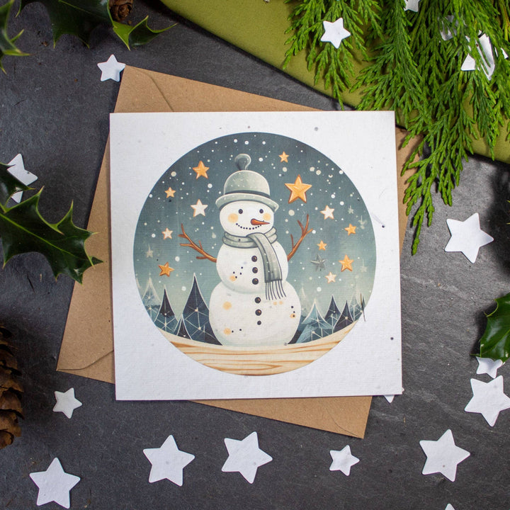 Christmas card with a snowman illustration on a dark surface with decorative elements.
