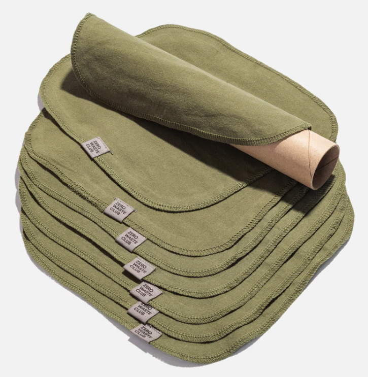 Stack of green fabric products with labels on a white background