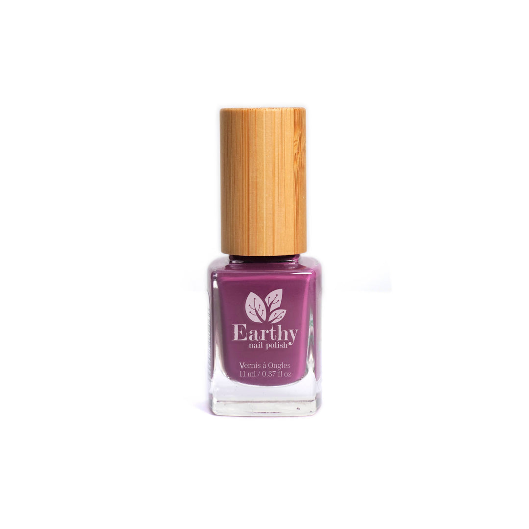 Earthly nail polish bottle with a wooden cap. Purple nail varnish on a white background.