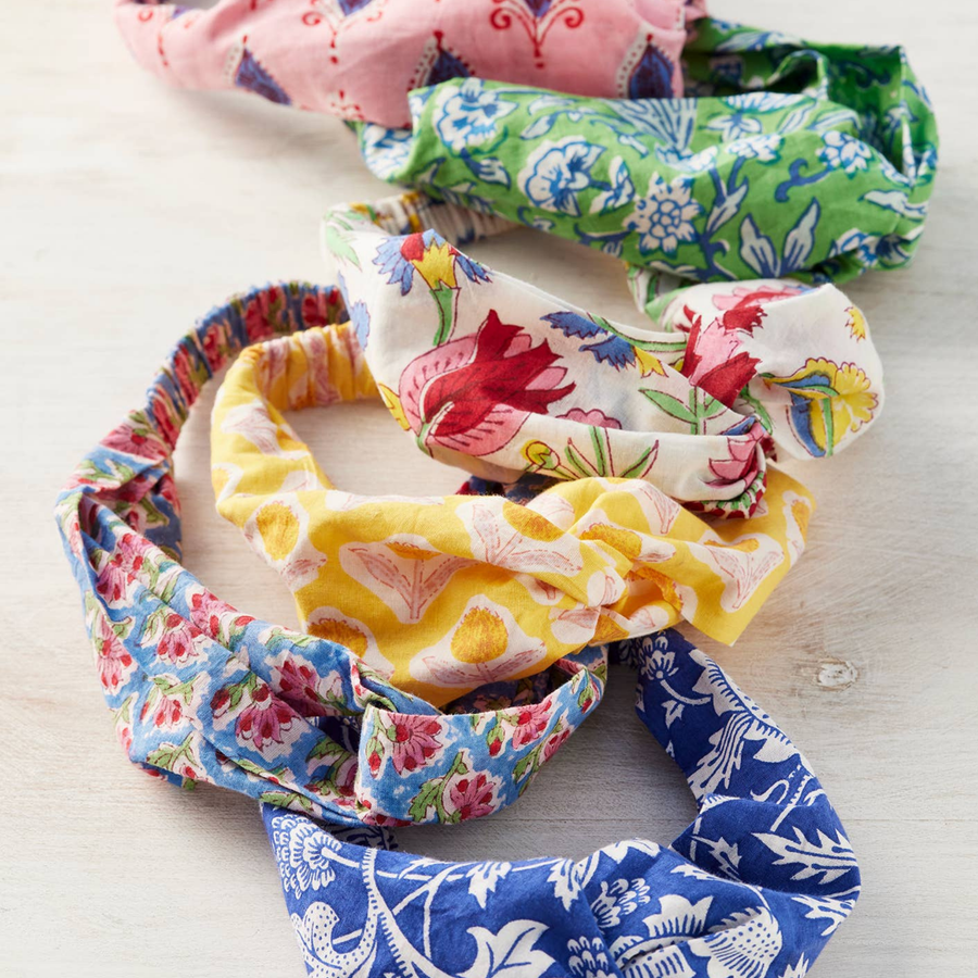 Colourful floral-patterned headbands on a light wooden surface