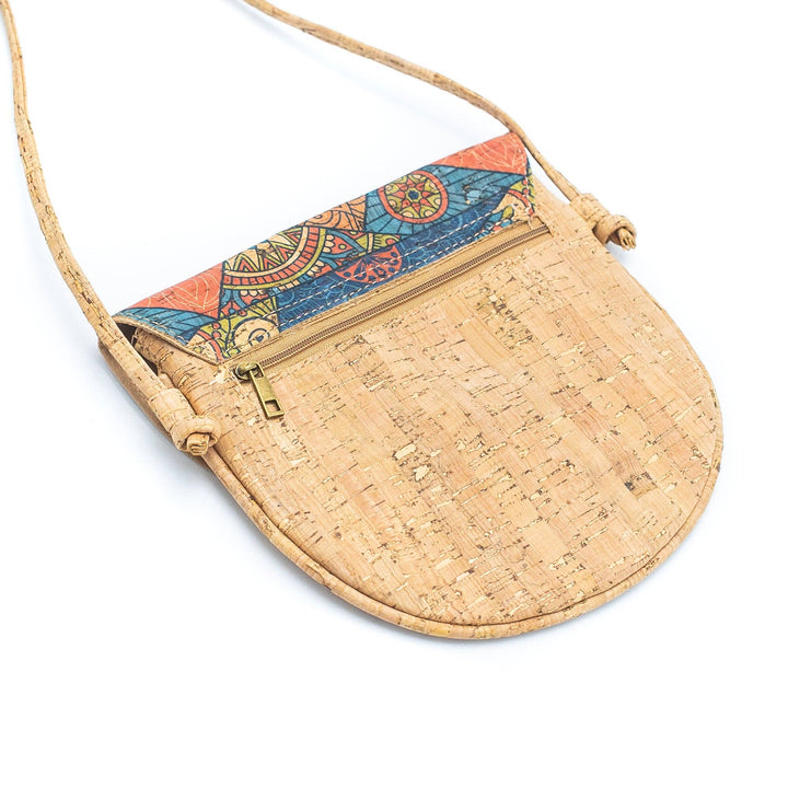 A natural cork messenger bag with multicolored geometric patterned cork panels and a beige cork strap.