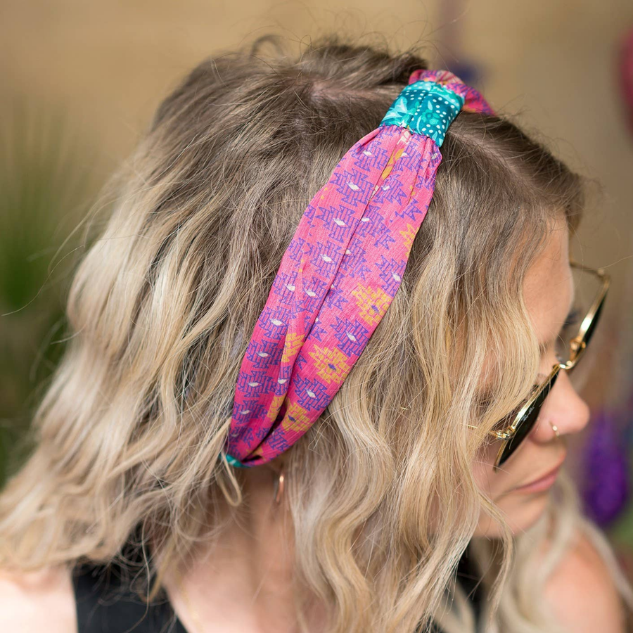 Person wearing a colorful headband with sunglasses on a blurred background
