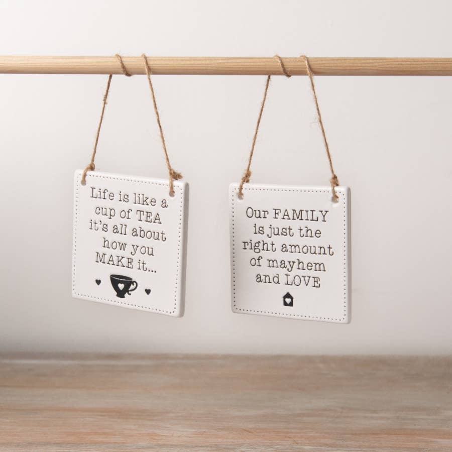 A chic engraved ceramic sign with a rustic jute string hanger with the phrase our family is just the right amount of mayhem and love. 