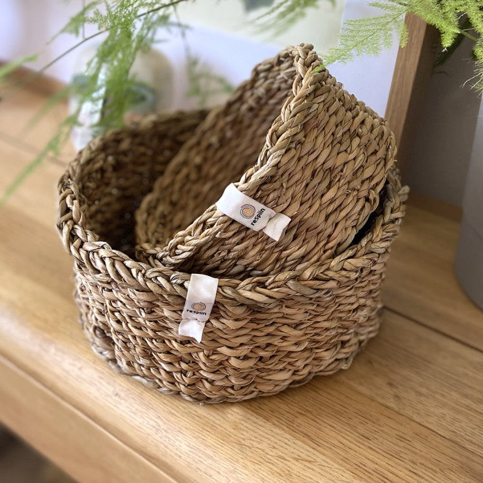 Woven natural seagrass baskets Small and medium stacked on one another.