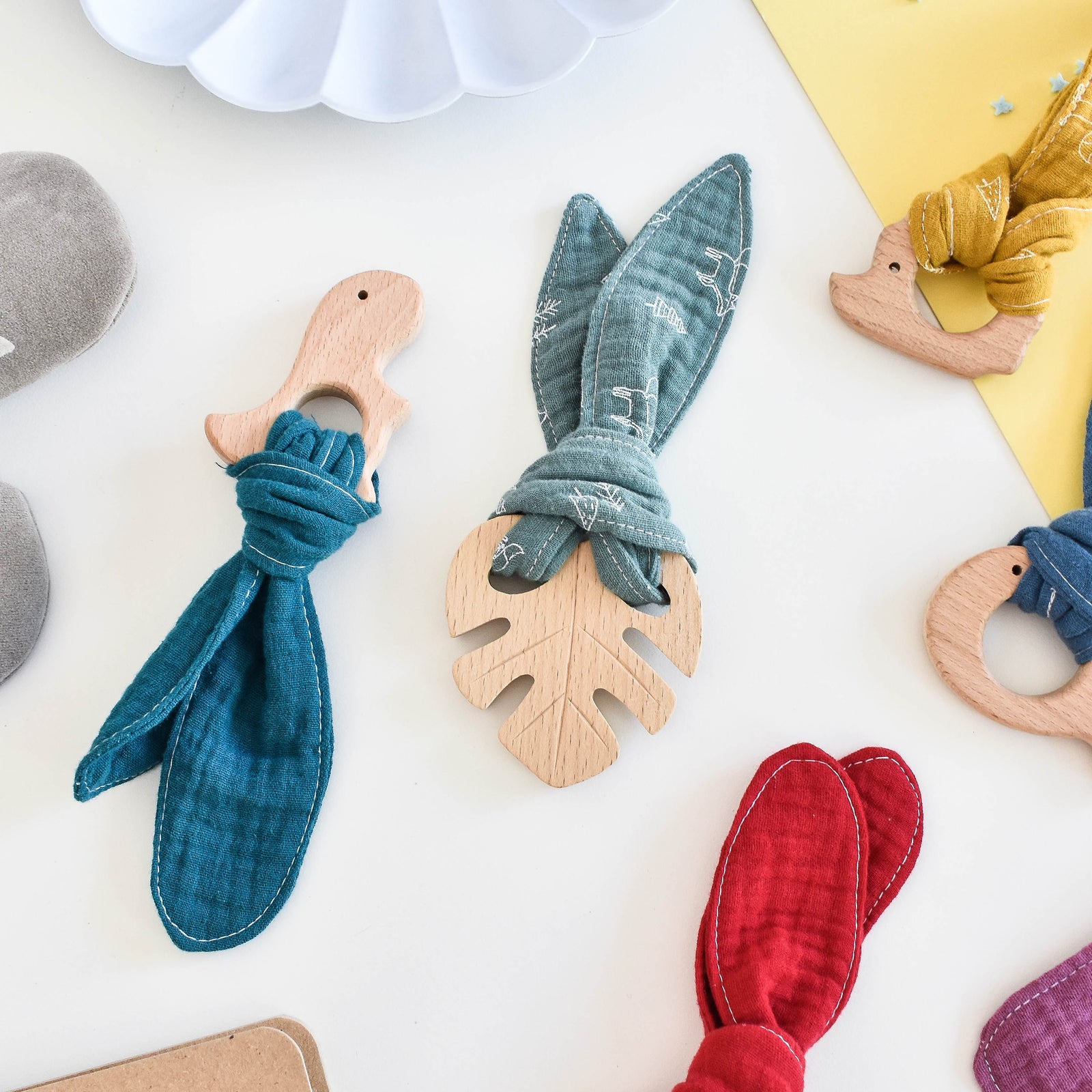 Natural beech teethers in a range of shapes with colour organic cotton muslin.