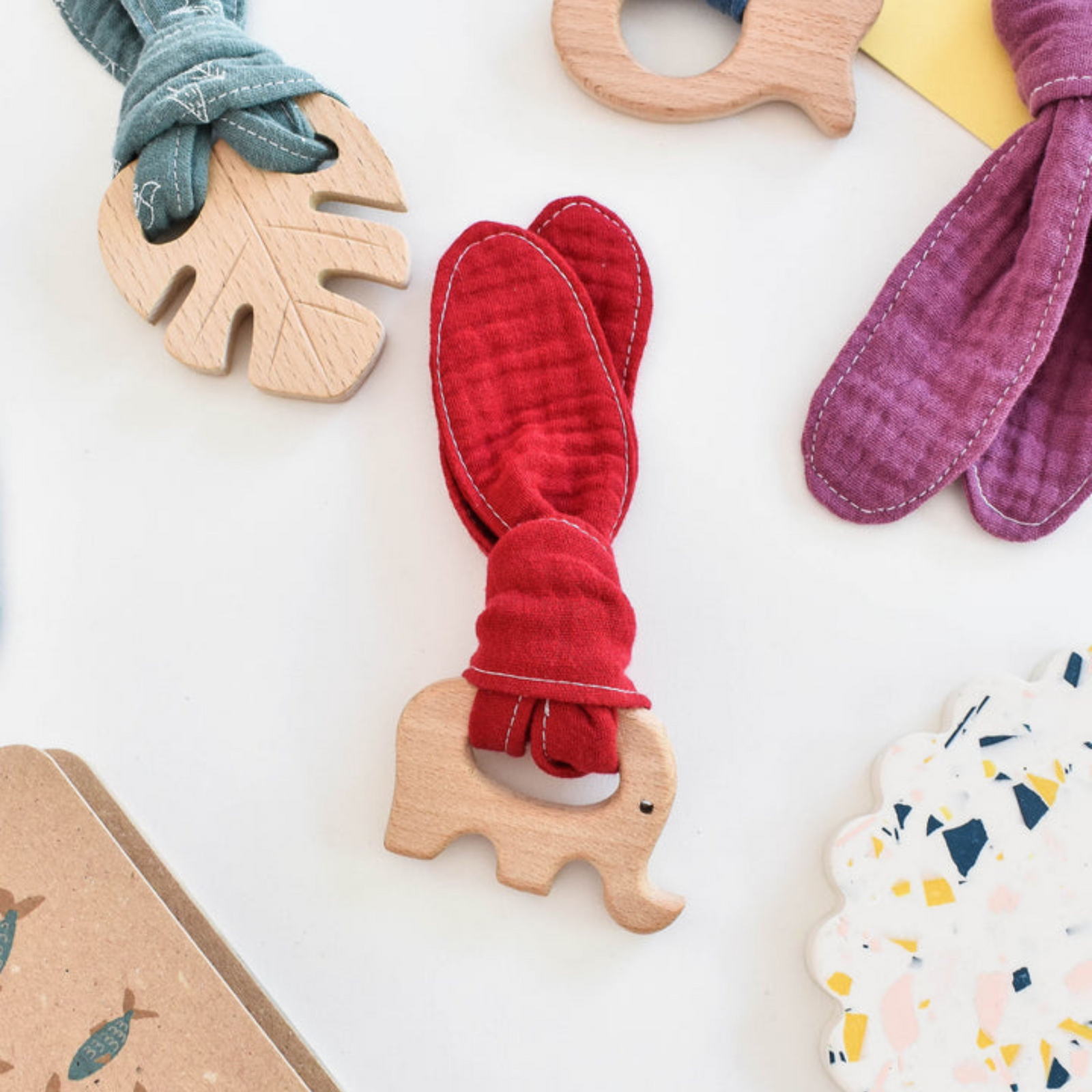Natural beech elephant teether shape and red organic cotton muslin.