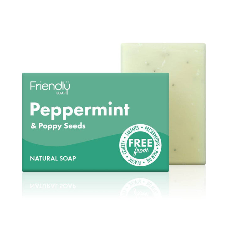 A bar of peppermint and poppy seeds natural soap next to its packaging, which is green and white with text and branding.