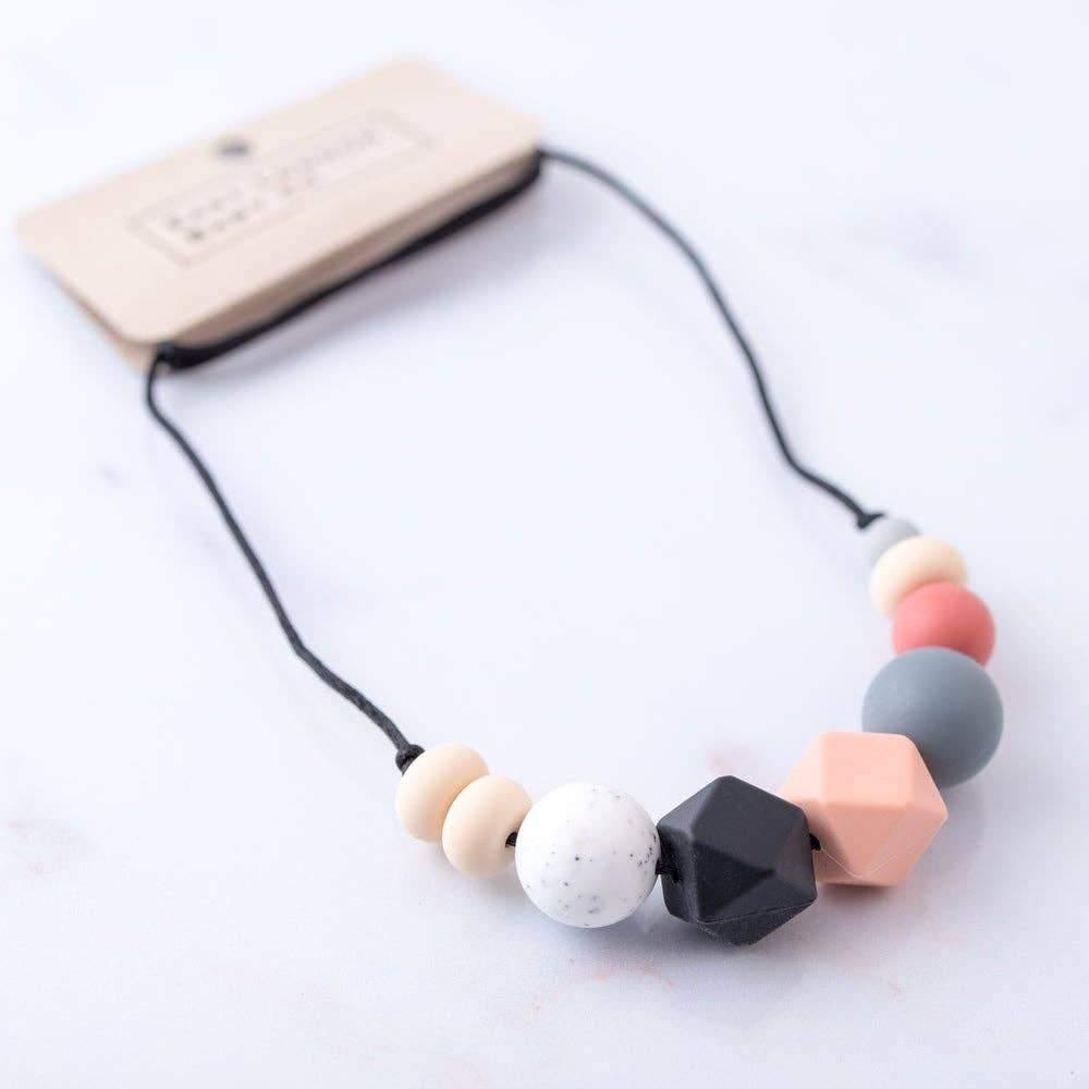 Bexley teething necklace with nudes, blacks and greys with a pop of vermilion red